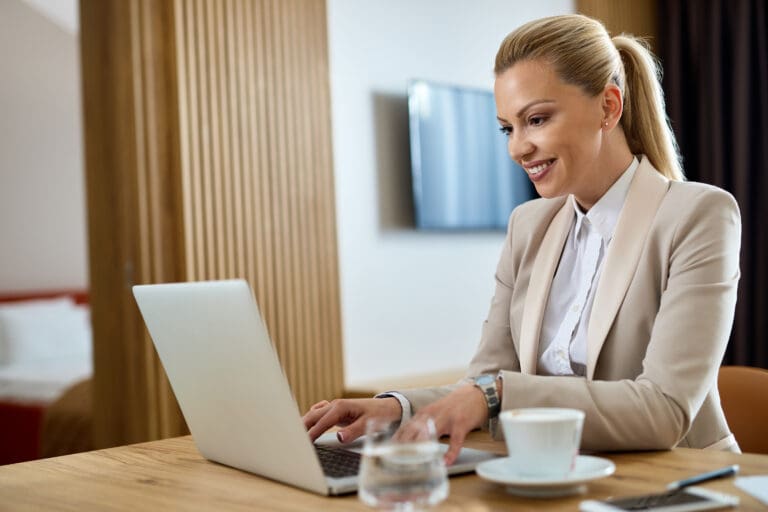 Professional businesswoman typing email on laptop in office setting