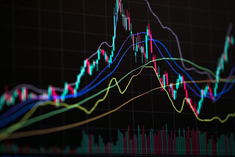 Colorful candlestick stock market chart with trend lines on dark background.